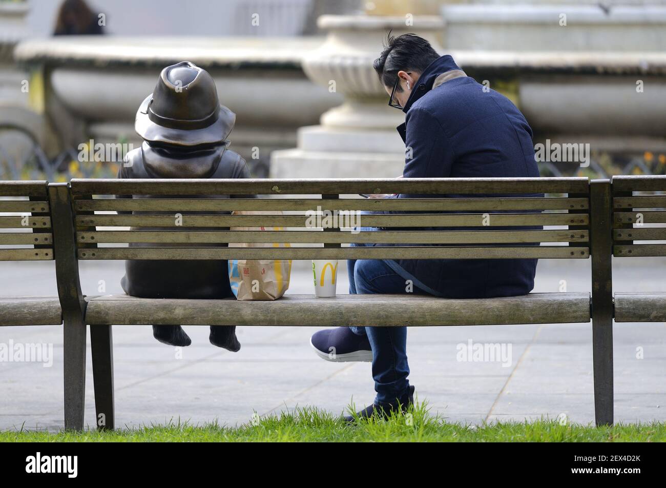 London, England, UK. Sharing a takeaway lunch with Paddington Bear in Leicester Square during the COVID restrictions, March 2021 Stock Photo