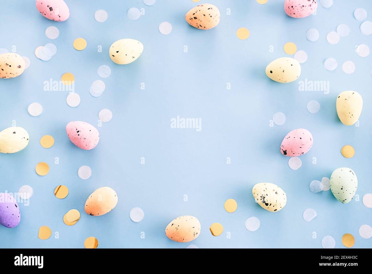 Multicolored motley easter eggs on a blue background with copy space for text Stock Photo