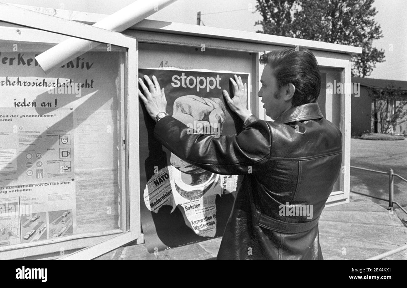 15 August 1982, Saxony, Delitzsch: Stop the NATO double decision. In the KFL Kreisbetrieb für Landtechnik Döbernitz (Delitzsch district), an employee puts up a poster in the showcase in mid-1982. The exact date of the photograph is not known. Photo: Volkmar Heinz/dpa-Zentralbild/ZB Stock Photo