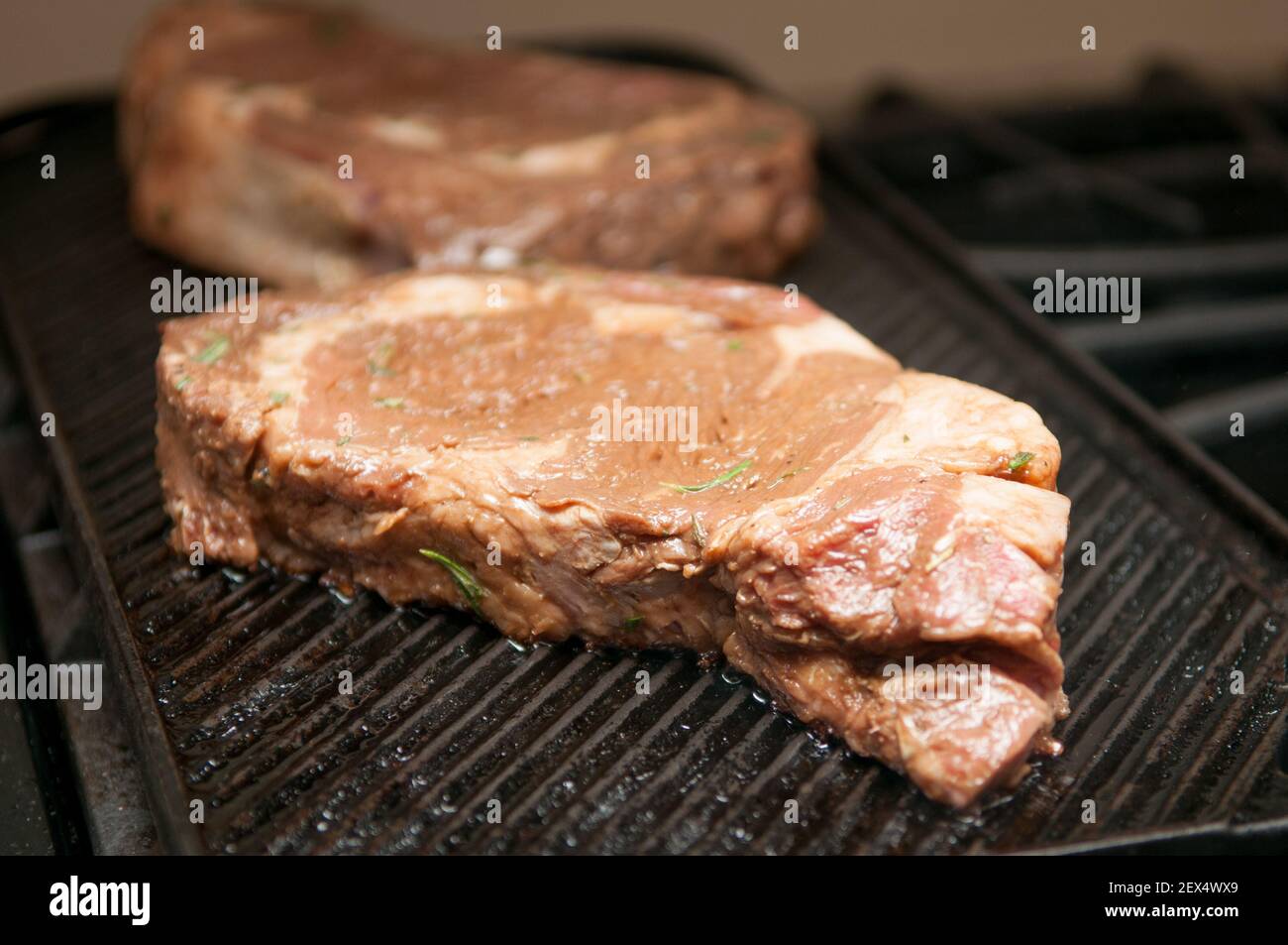 thick ribeye steak seared rare on a cast iron grill Stock Photo Alamy