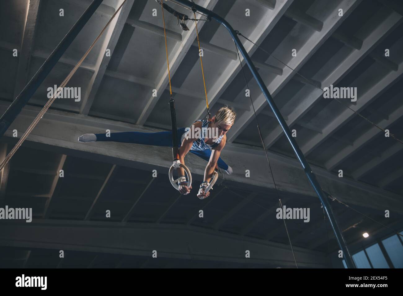 Flying. Little male gymnast training in gym, composed and active ...