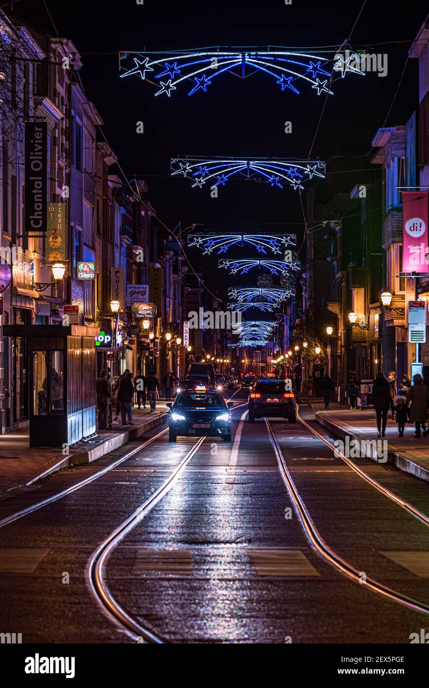 The Ferdinand Lenoir street, a shopping street with christmas decoration and a lightrail tramway track by night Stock Photo