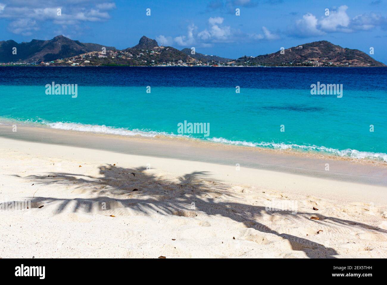 Palm Tree Shadow on a Caribbean Beach with Turquoise Caribbean ocean and Union island: Casuarina Beach, Palm Island, Saint Vincent and the Grenadines Stock Photo