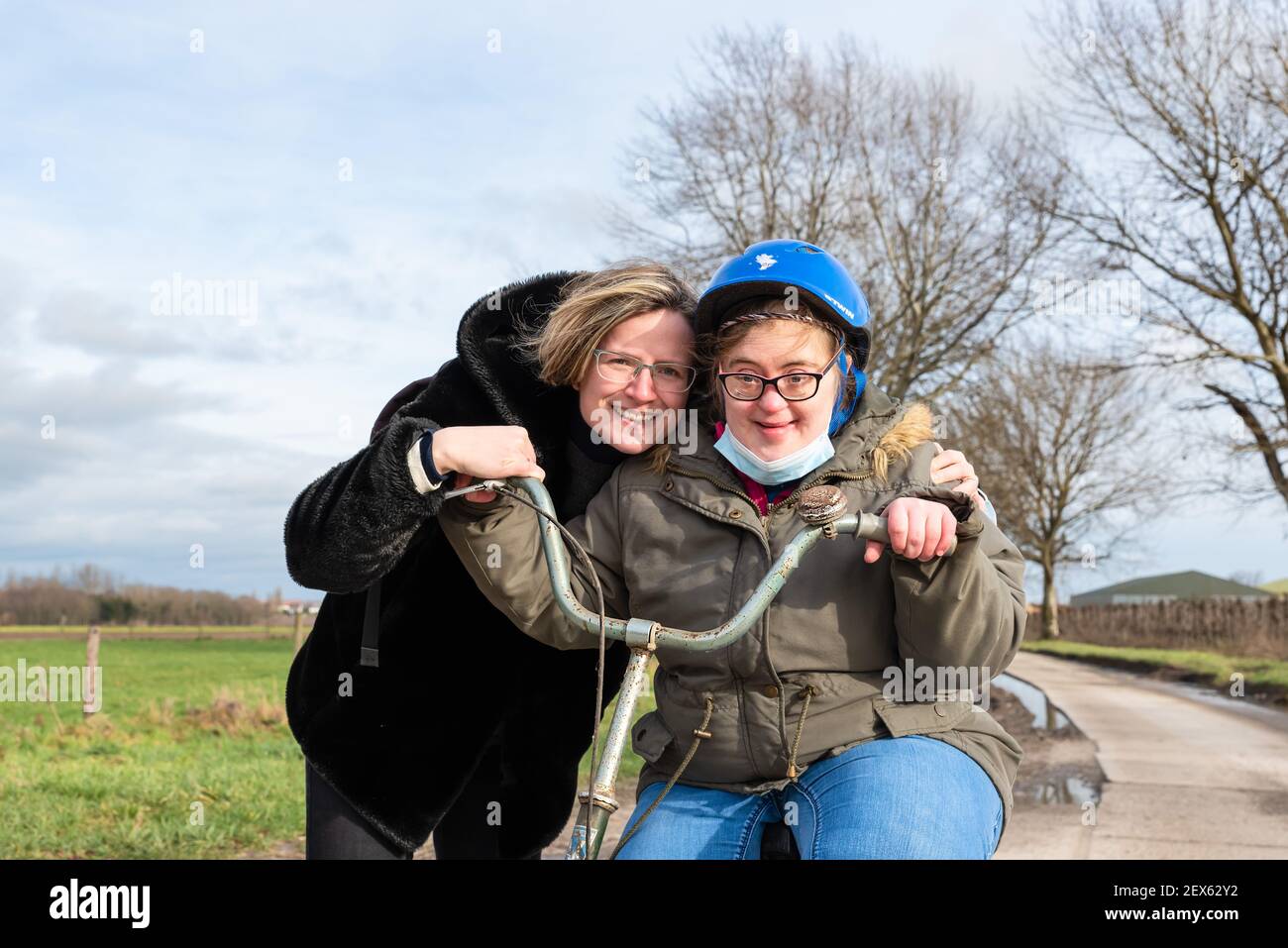 Portrait of a happy Down Syndrome woman of 37 years old smiling on her bicycle Stock Photo