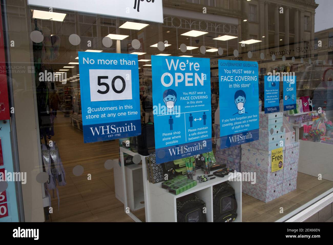 Shop with COVID noctices in windows restricting numbers of customers and compulsory face coverings W H Smith Cheltenham UK Stock Photo