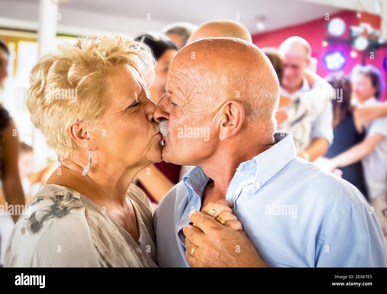 Happy senior retired couple having fun on dancing at restaurant wedding celebration party - Love concept of joyful elderly and retirement lifestyle Stock Photo