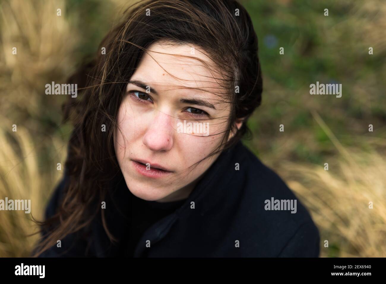 Outdoors portrait from above of a 28 year old white woman with brown hair and a nature background Stock Photo