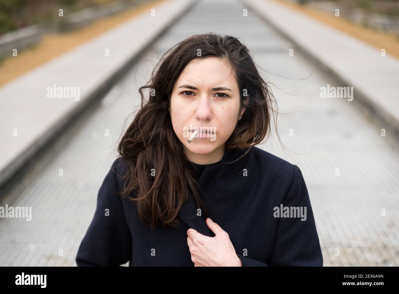 Outdoors portrait of a 28 year old white woman with brown hair, smoking Stock Photo