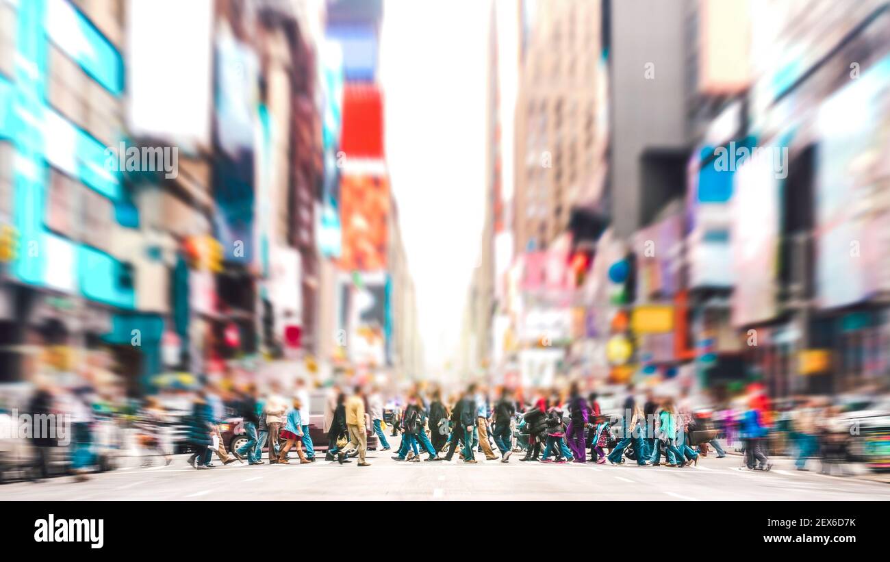 Defocused background of people walking on zebra crossing on 7th avenue in Manhattan - Crowded streets of New York City during rush hour in urban area Stock Photo