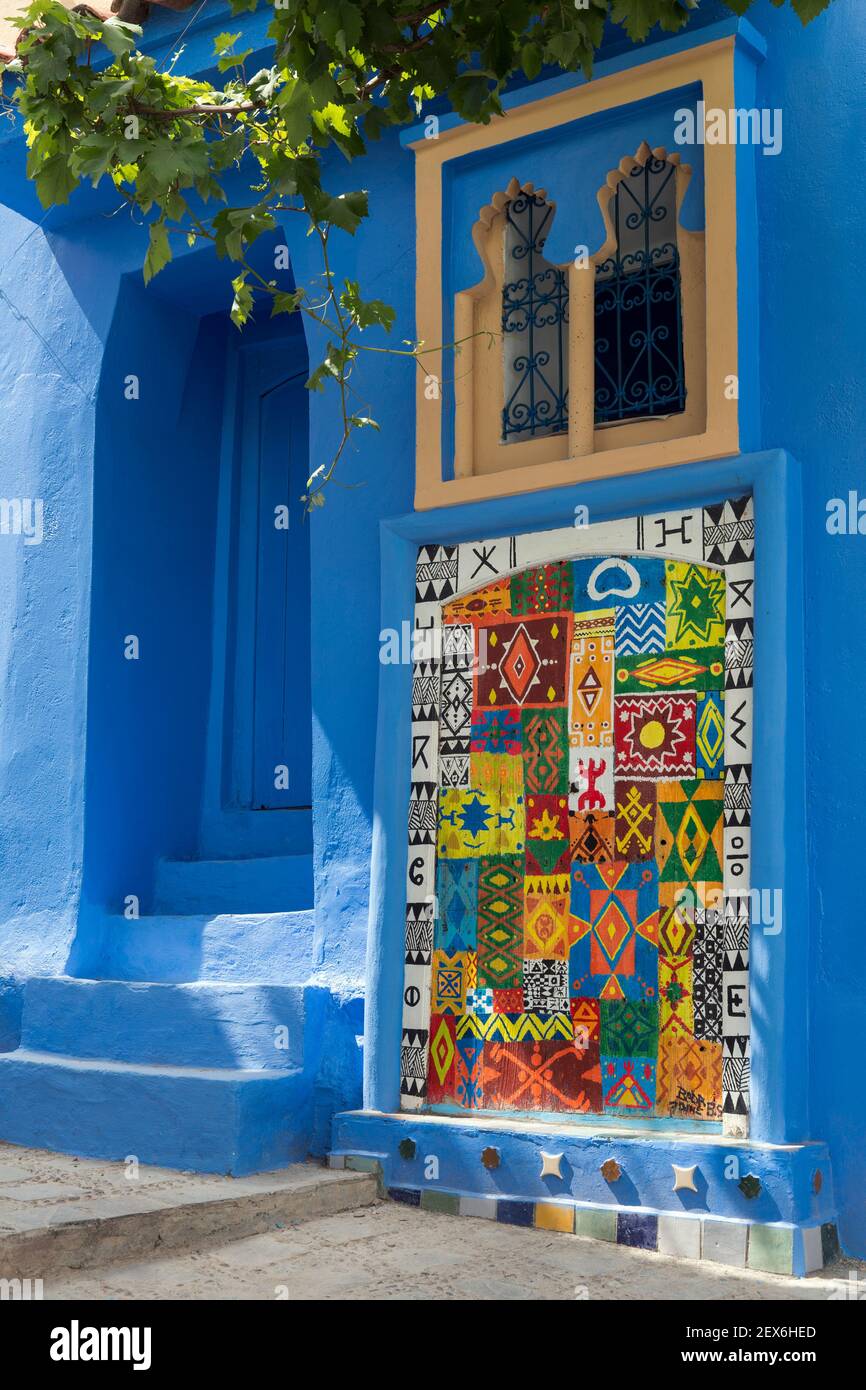 Morocco, Chefchaouen, 'the blue city' architecture of white and indigo lime washed buildings with art displayed on wall Stock Photo
