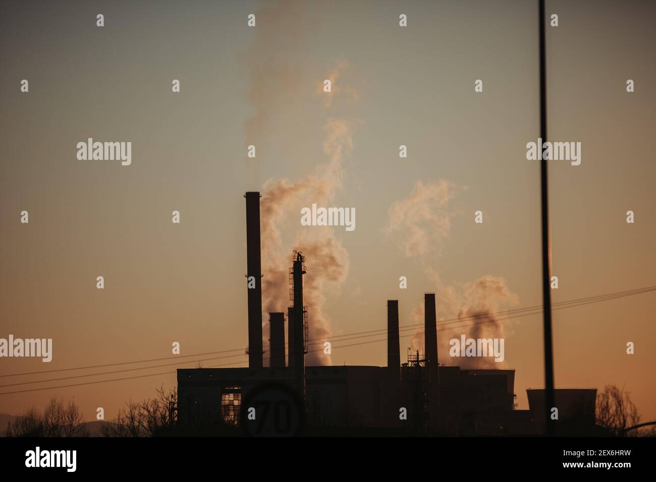 Silhouette of industrial chimneys with smoke in sunset Stock Photo - Alamy