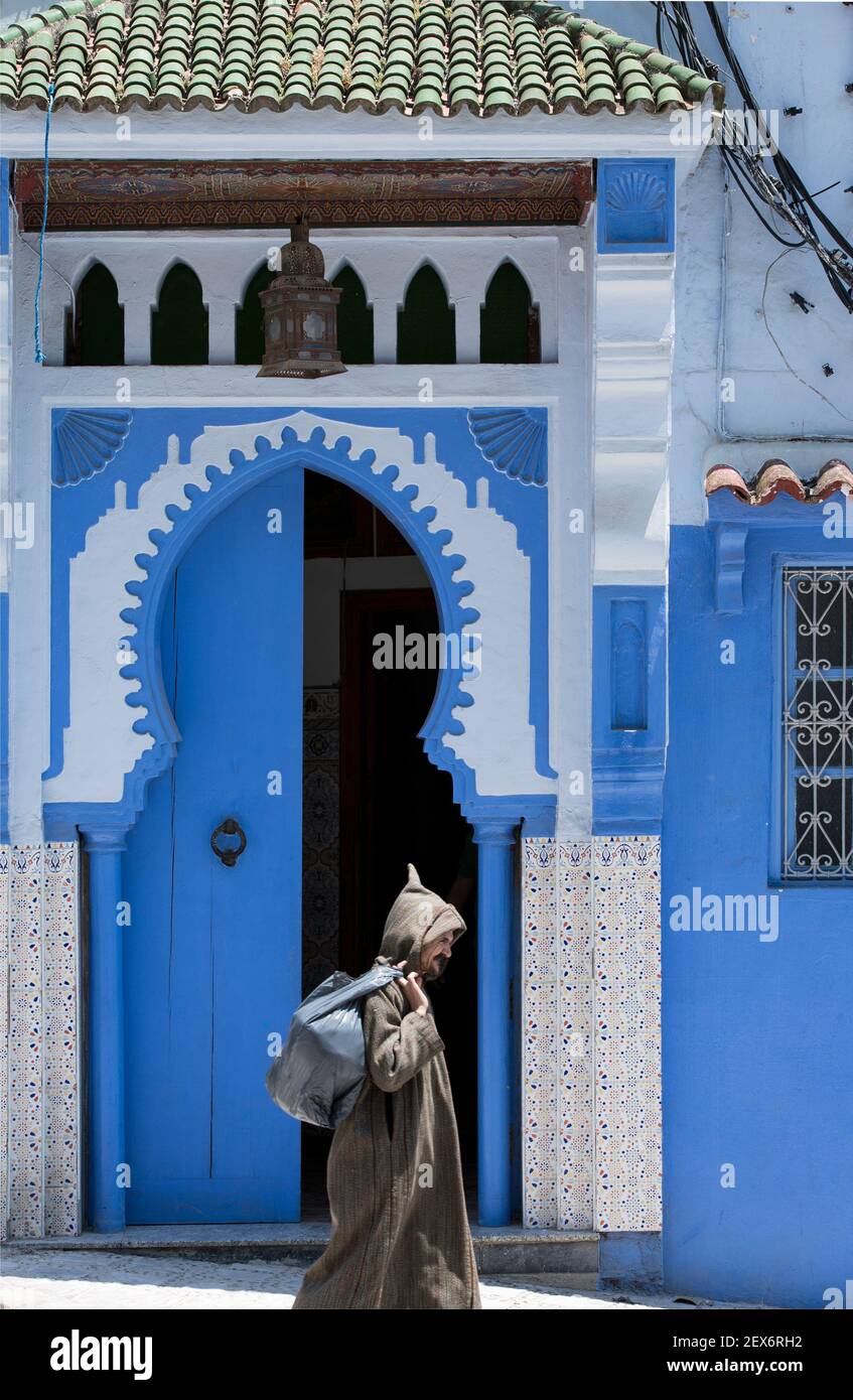 Morocco, Chefchaouen, architecture of white and indigo lime washed buildings with person Stock Photo