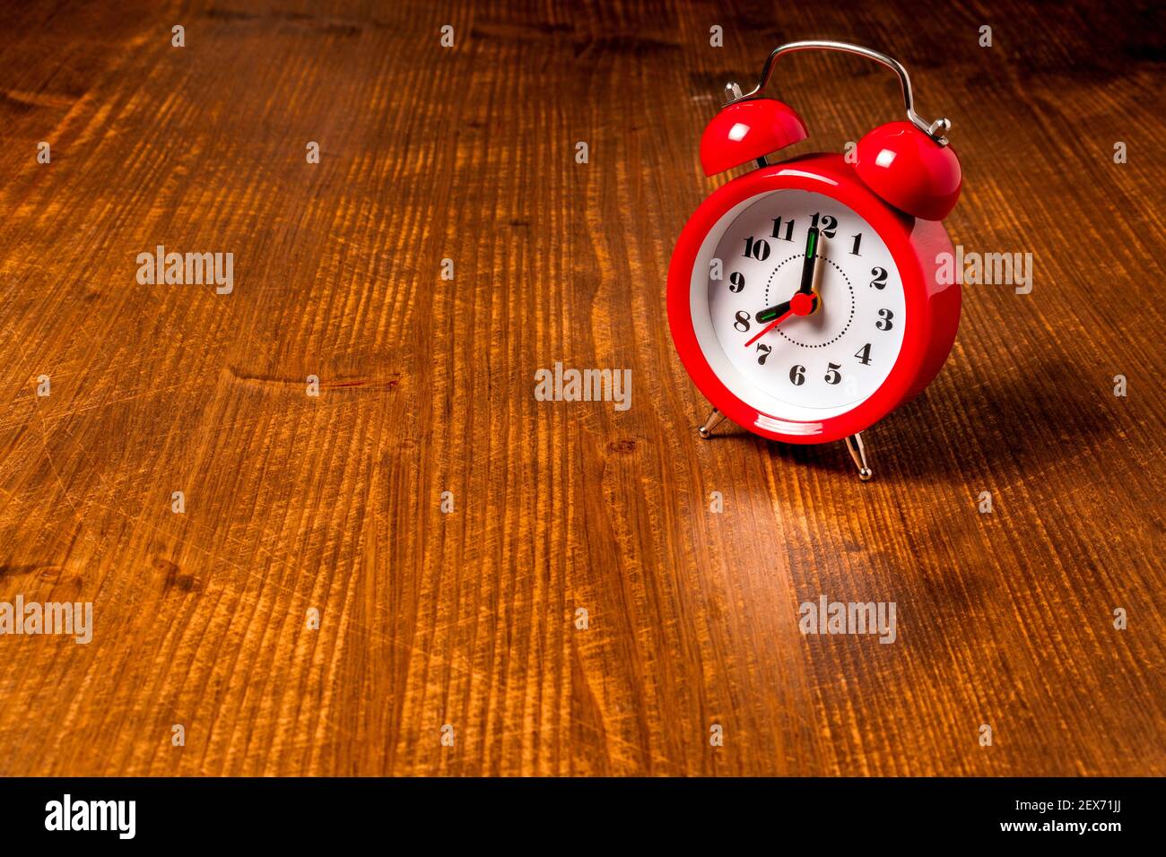 Old fashioned red alarm clock on the old wooden table background Stock ...