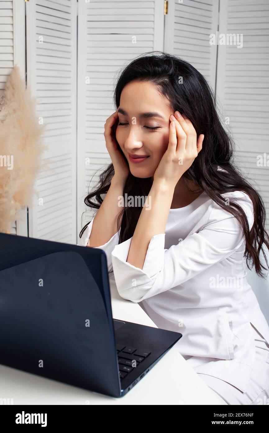 young pretty asian woman in white form working in clinic with laptop ...