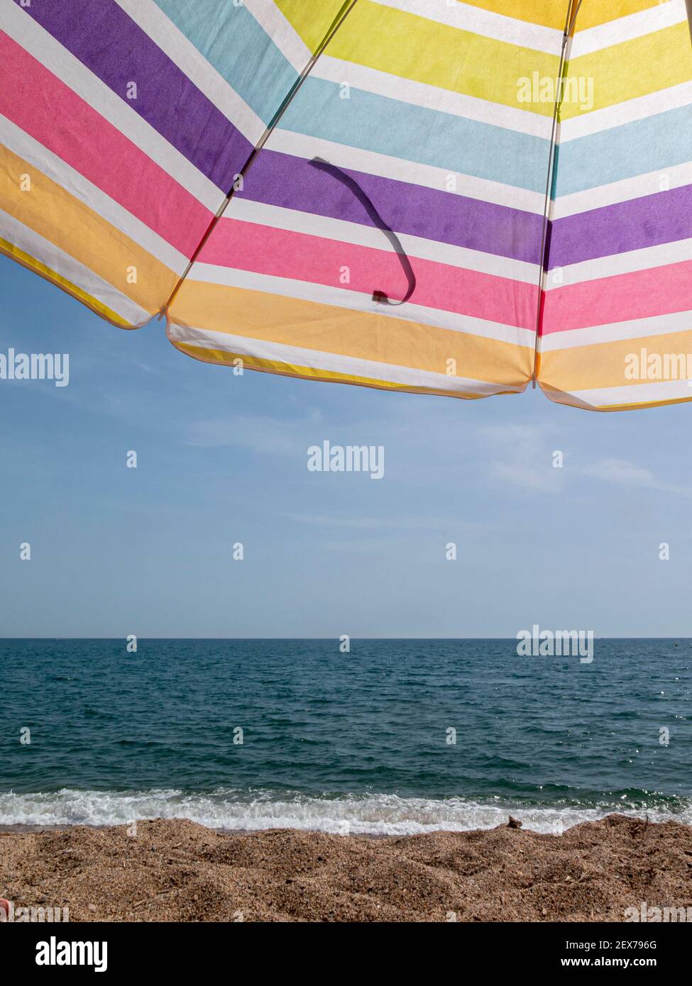 beach umbrella in the summer of spain with multi coloredin a blue sky