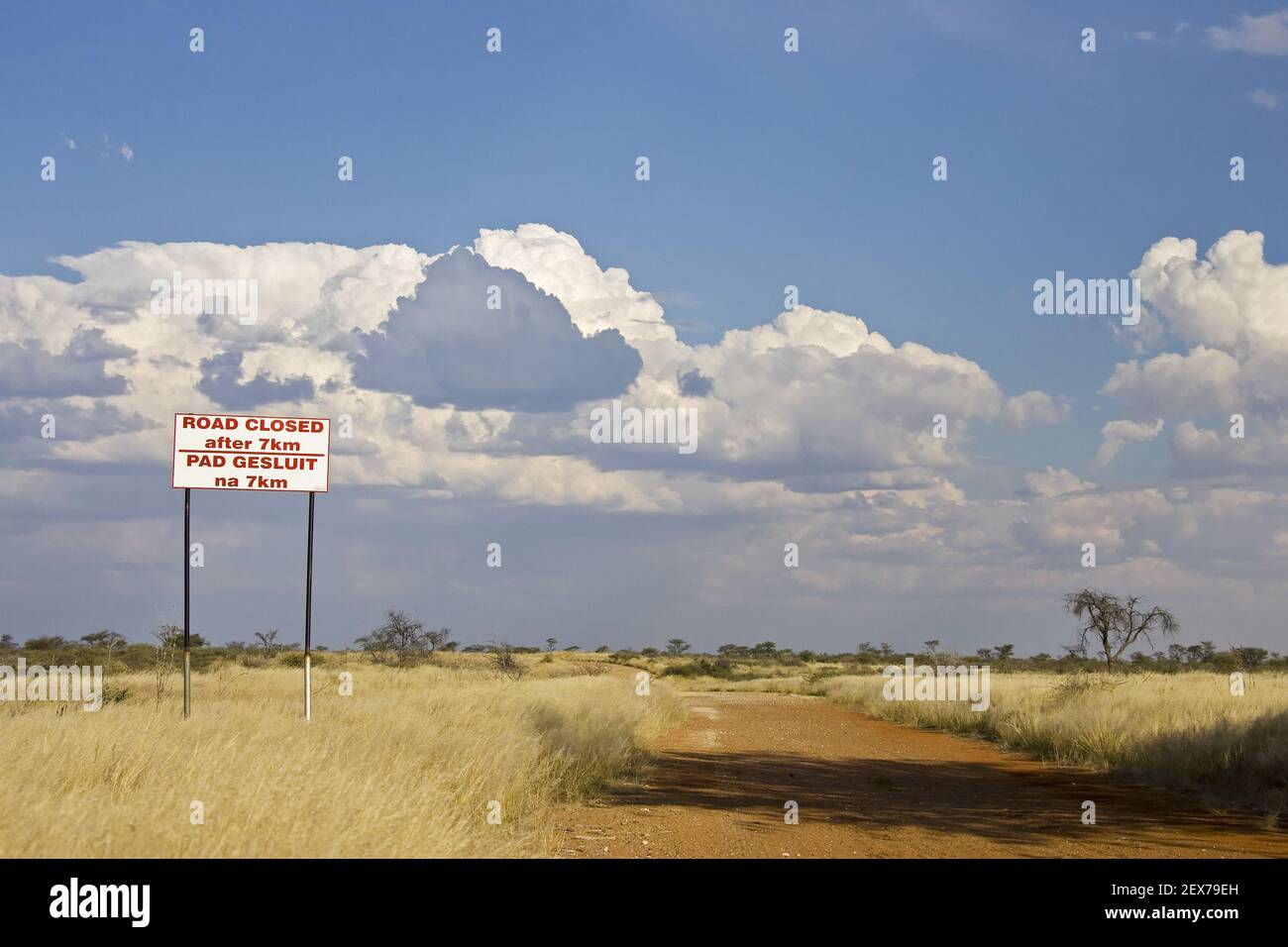 Warning cross in front of a railway crossing and sign with the inscription, Sign at railway crossing Road closed after 7 km, Nam Stock Photo
