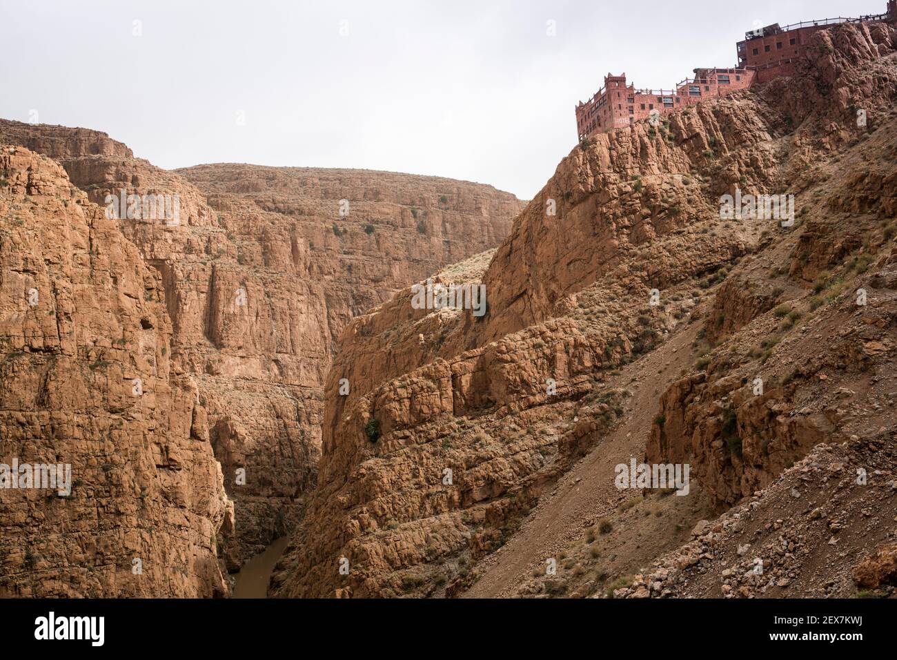 hotel perched on a cliff side overlooking a chasm or gorge in a barren landscape Stock Photo