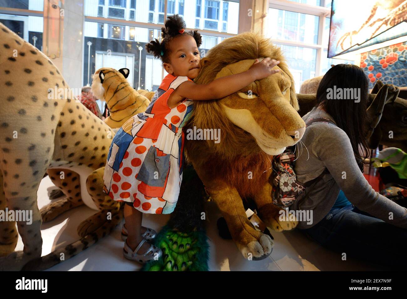 Two and half year-old Gracie Isaac hugs a plush toy lion inside FAO Schwarz  a few minutes before the store's Fifth Avenue flagship store closes it's  doors for good in New York