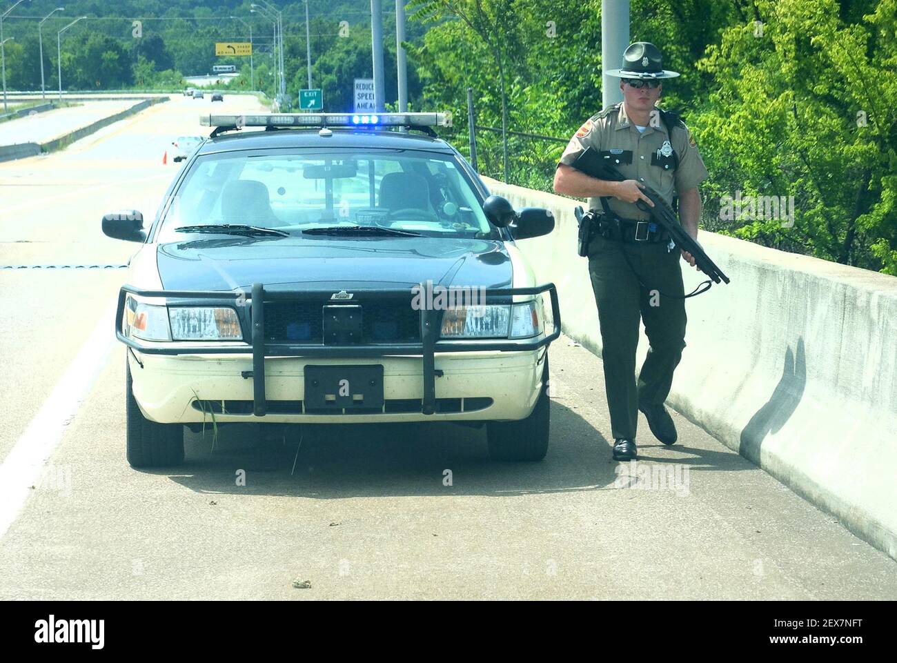 Tennessee Highway Patrol Trooper Paul Clendenen guards the top of the C.B.  Robinson Bridge above the Tennessee River after a morning shooting at the  Naval and Marine Reserve Center at the Chattanooga, image size:1300x961