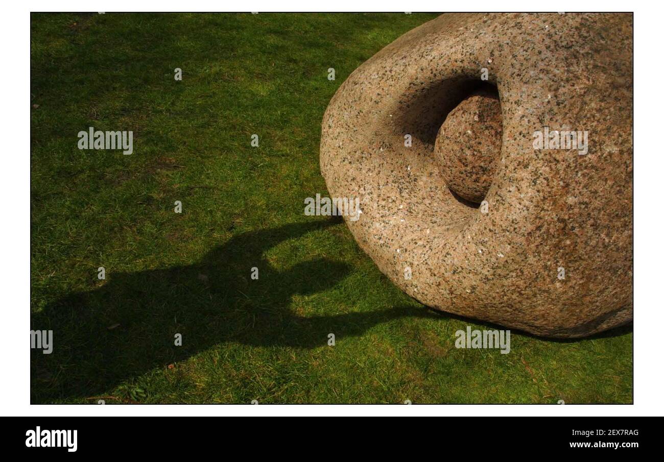 18 Tonnes of granite glacial boulder and bronze art, by British sculptor Peter Randall-Page was delivered to the Natural History Museums west lawn. The exhibition marks the start of Spring. 'Stone Bearing Stone' with shadow of the artist.pic David Sandison 27/3/2003 Stock Photo