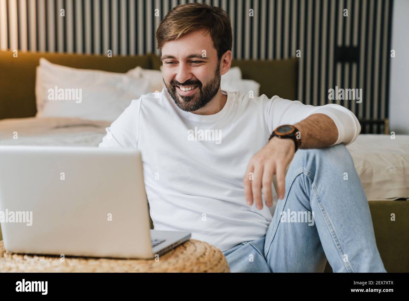 Smiling handsome man using laptop coputer at home Stock Photo