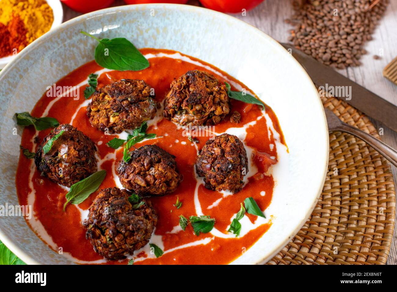 Vegan dish with oriental tomato soup and lentil nuts meatballs Stock Photo