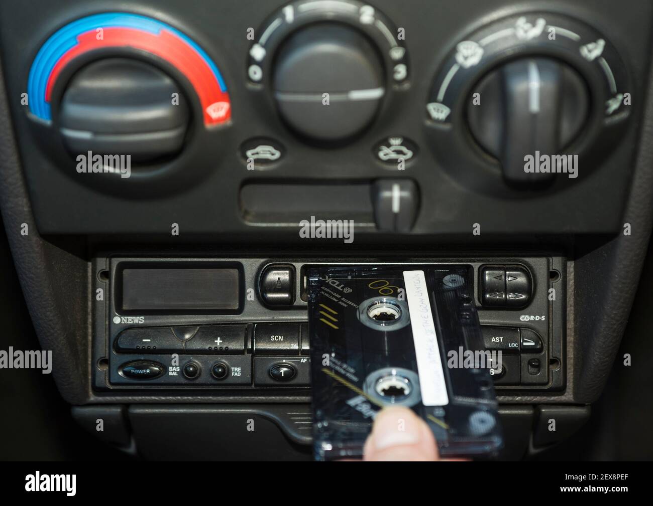 A hand placing a music cassette tape into a car's tape deck Stock Photo Alamy