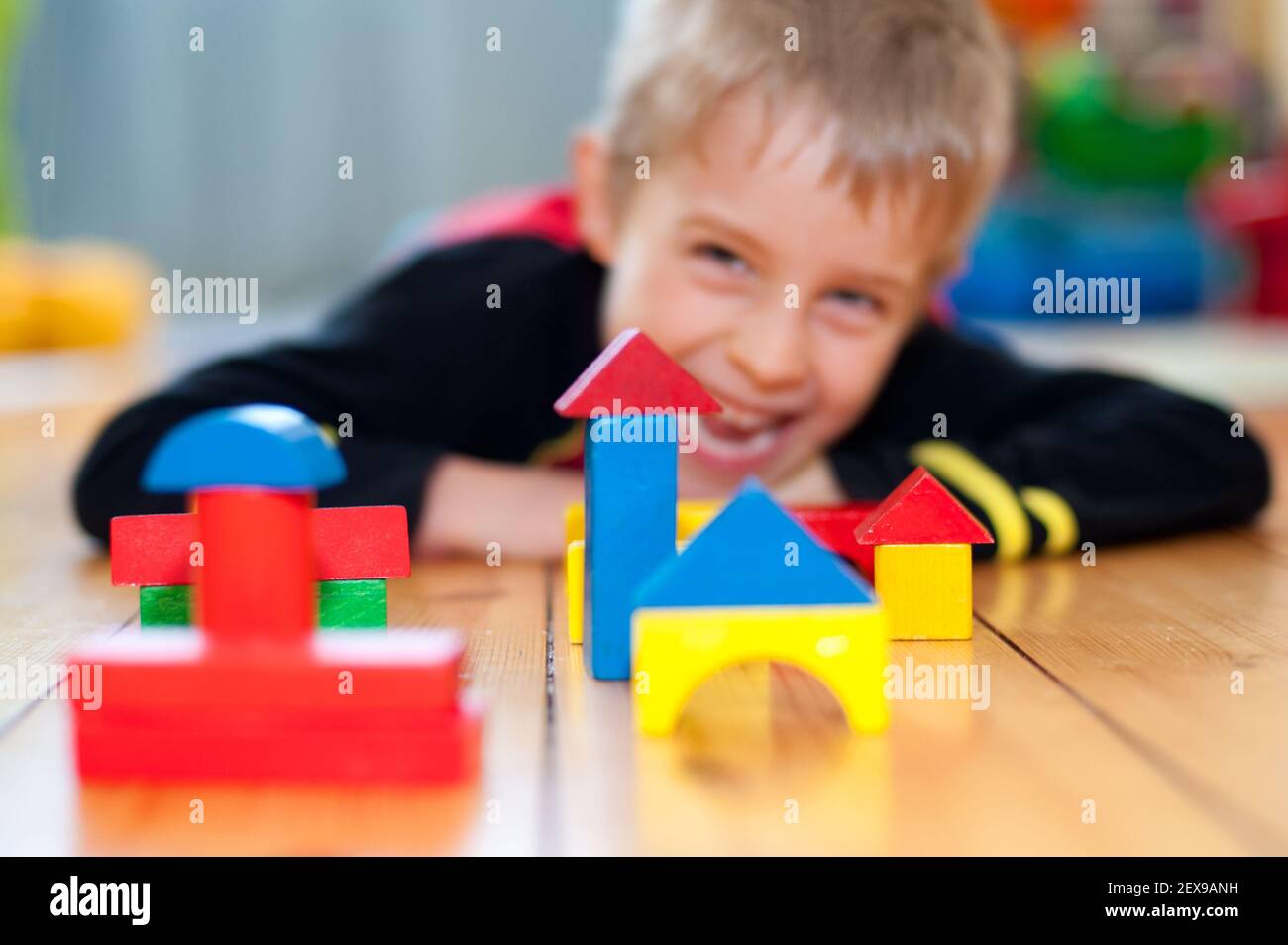 Little boy playing with wooden construction cubes Stock Photo