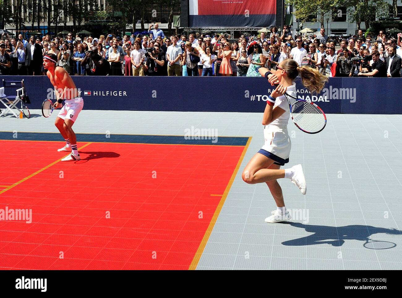 Model Hannah Davis hits a volley while model Arthur Kulkov watches at the Tommy  Hilfiger "TommyXNadal" celebrity tennis event in Bryant Park in New York,  NY on August 25, 2015. (Photo by
