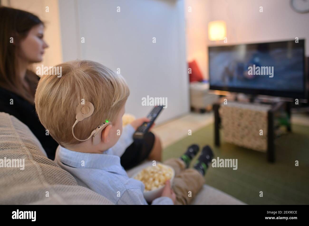 A Boy With Cochlear Implants watching Television At Home Stock Photo