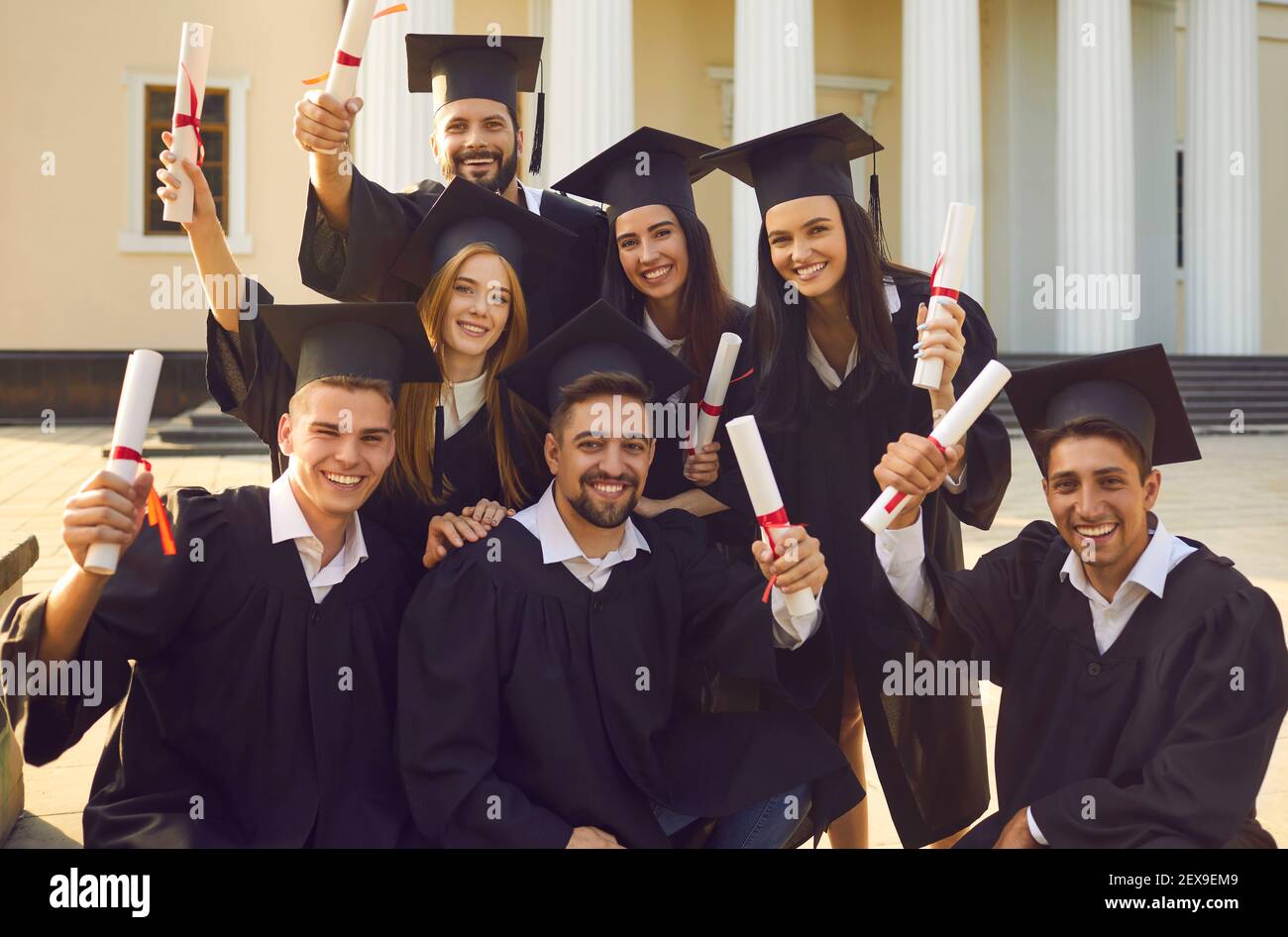Collective photo of smiling boys and girls students university graduates celebrating getting diplomas Stock Photo