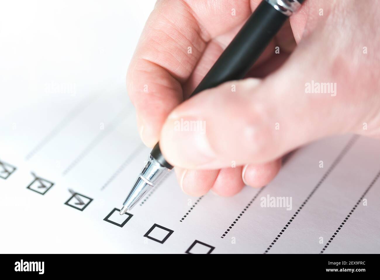 close-up of person ticking off checklist with ballpoint pen Stock Photo
