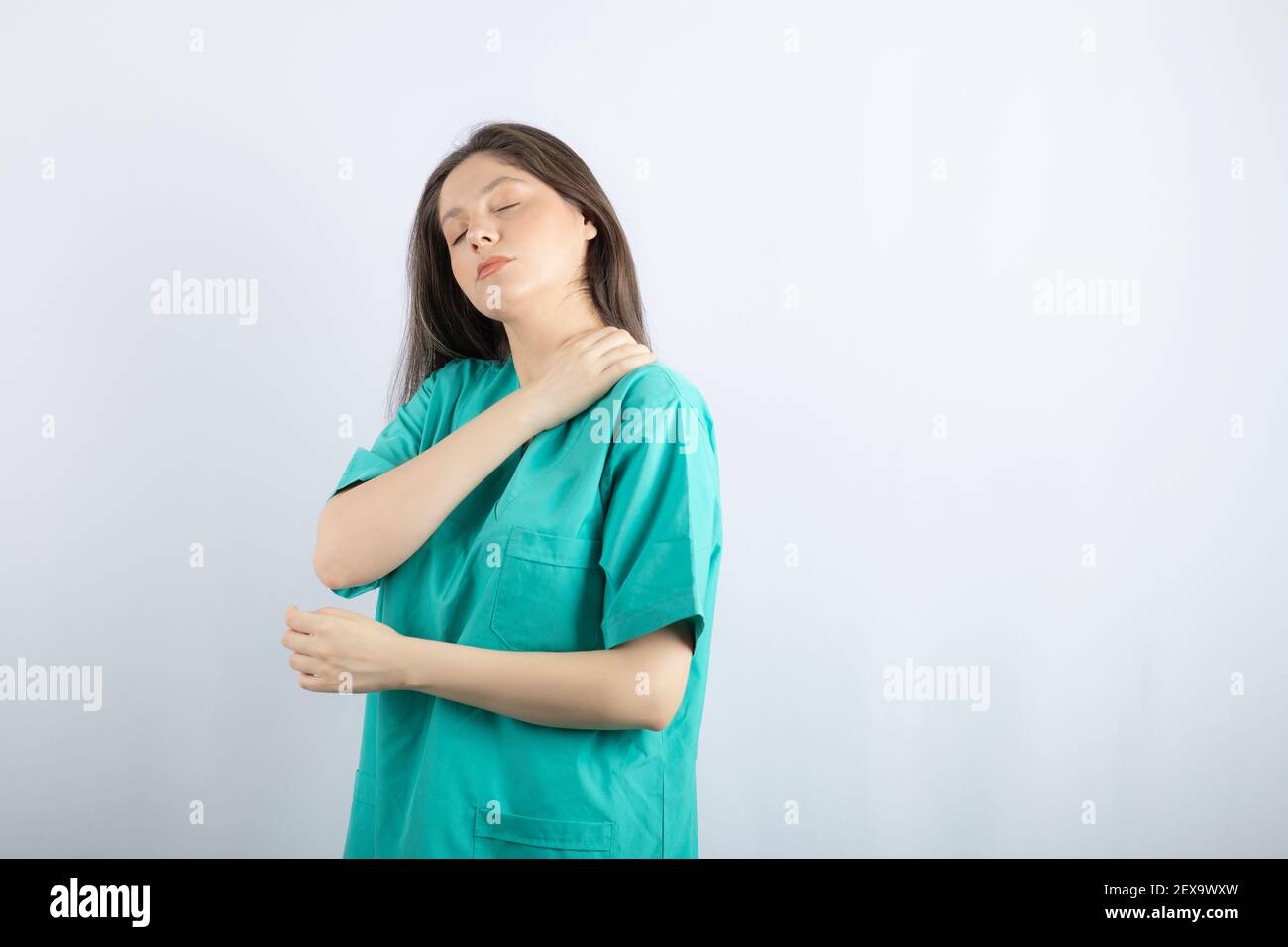 Tired medical worker girl massaging herself's neck Stock Photo - Alamy