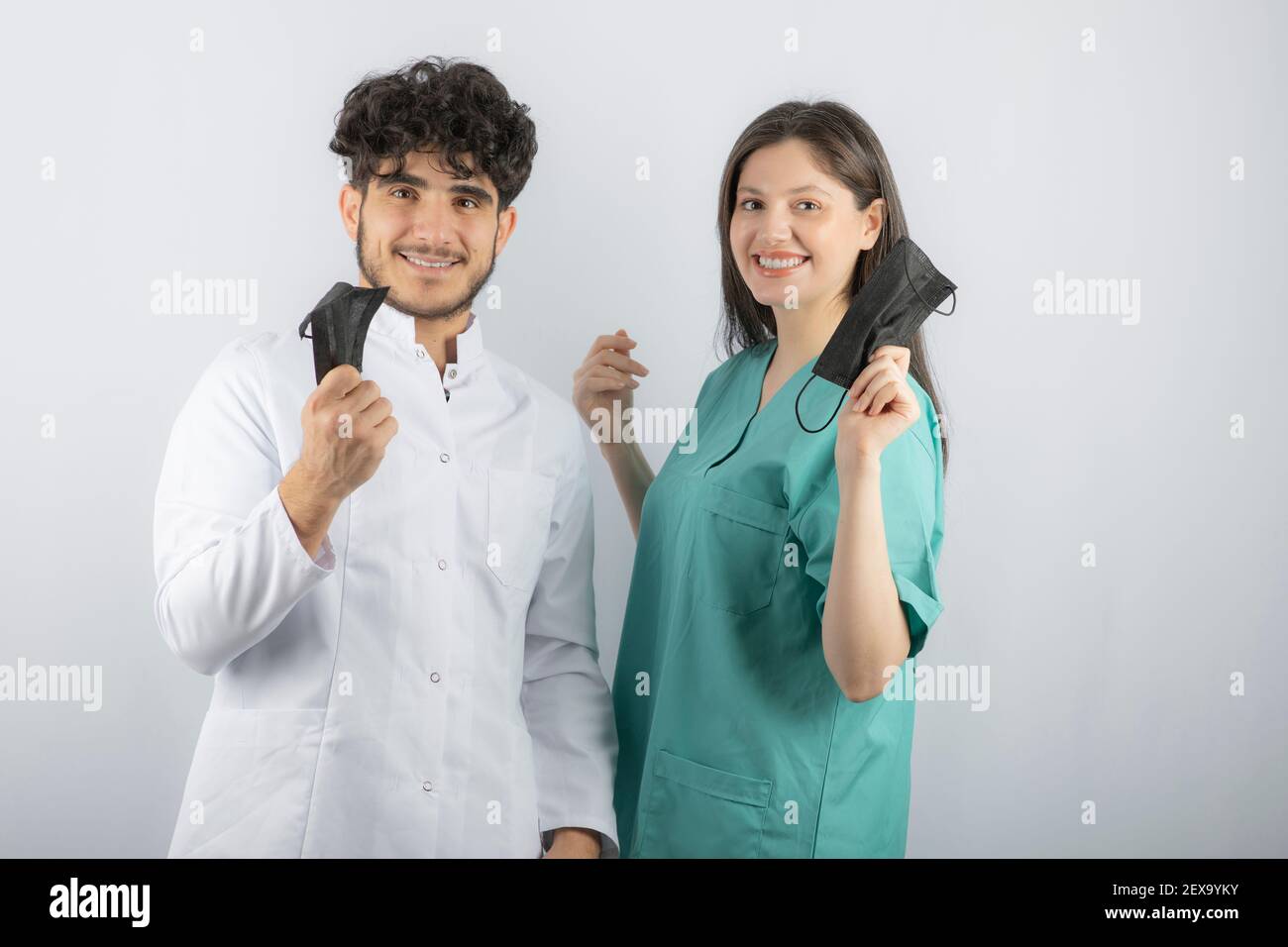 Smiling medical workers holding their masks up Stock Photo