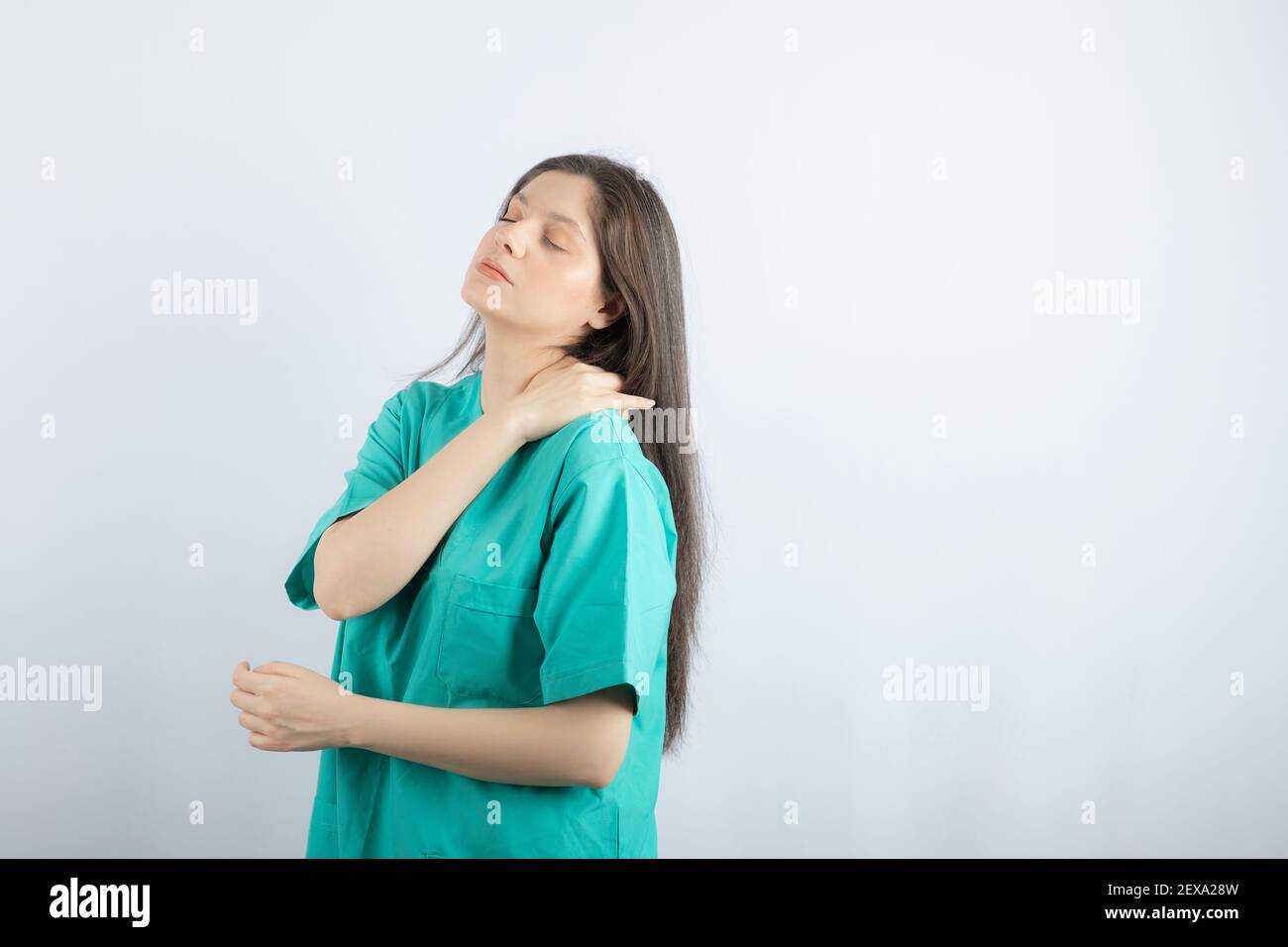 Tired medical worker girl massaging herself's neck Stock Photo - Alamy