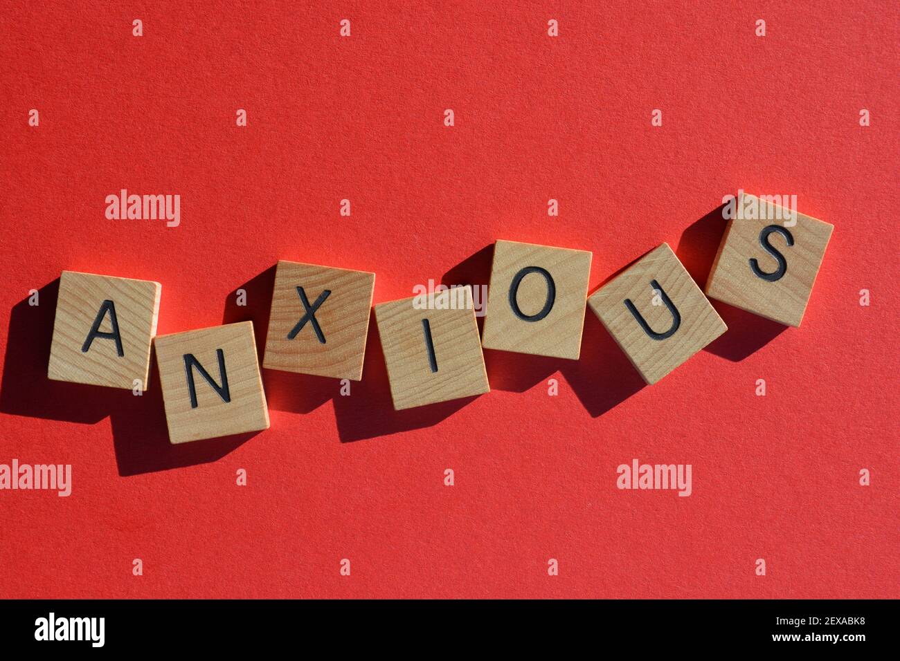 Anxious, word in wooden alphabet letters isolated on bright red background Stock Photo