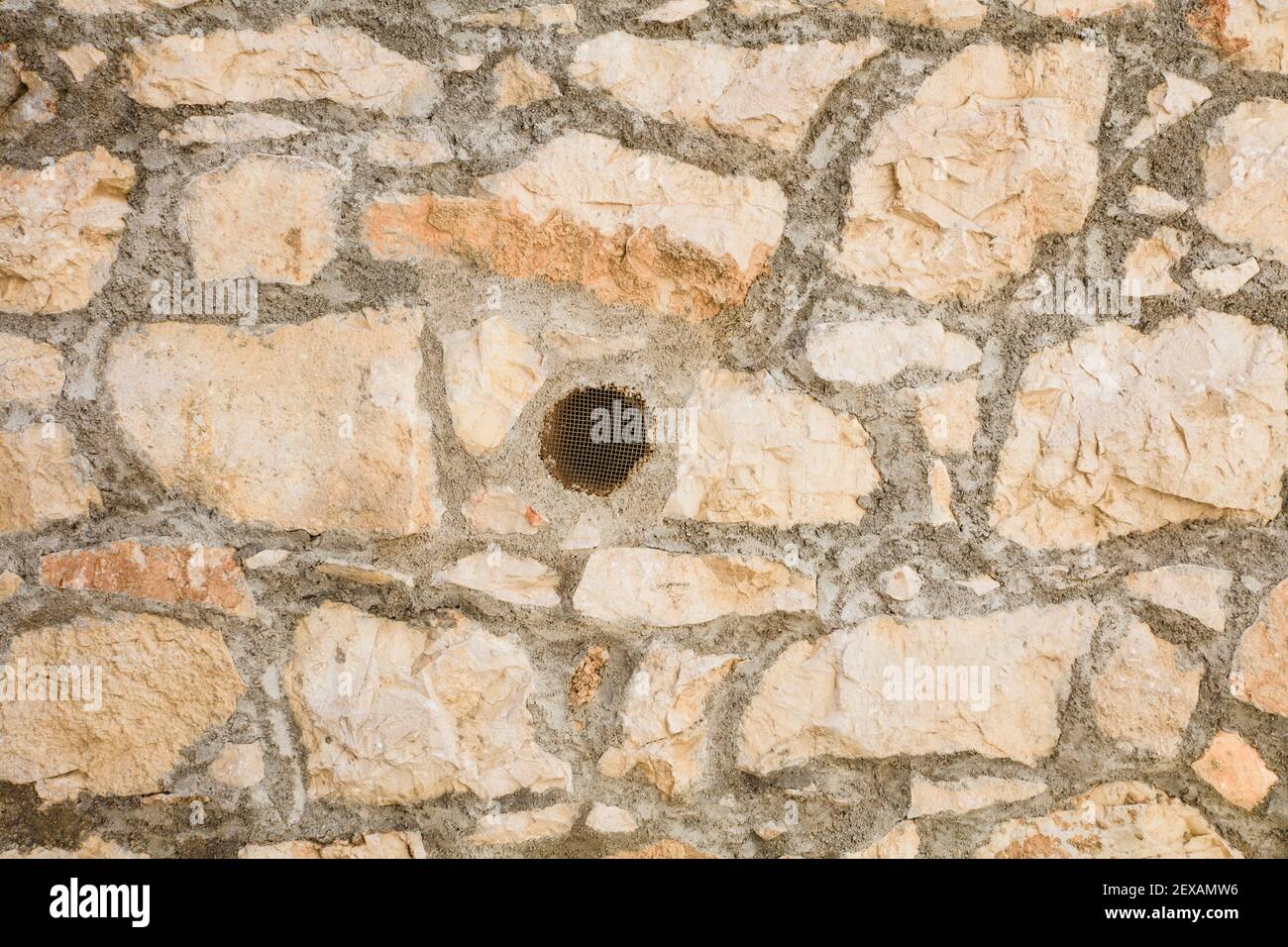 Stone built wall with a basic mesh air vent Stock Photo
