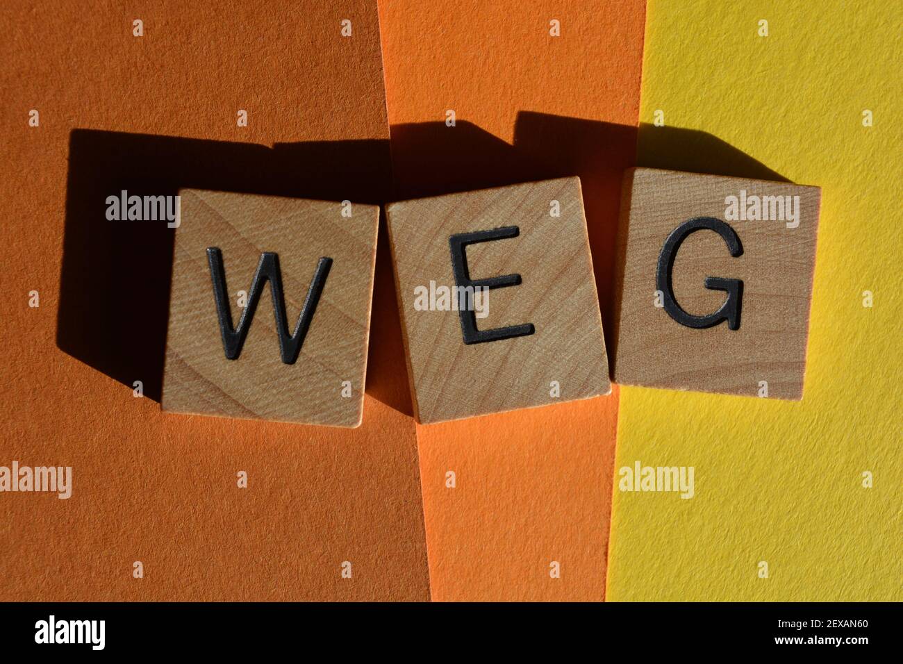 WEG acronym for Wicked Evil Grin in wooden alphabet letters isolated on colourful background Stock Photo