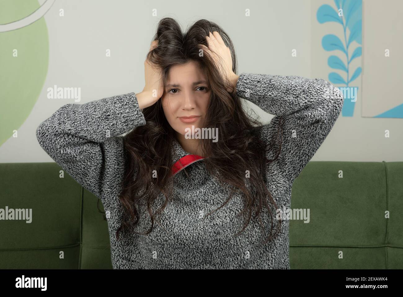 young beautiful woman holding her hands to her head Stock Photo - Alamy