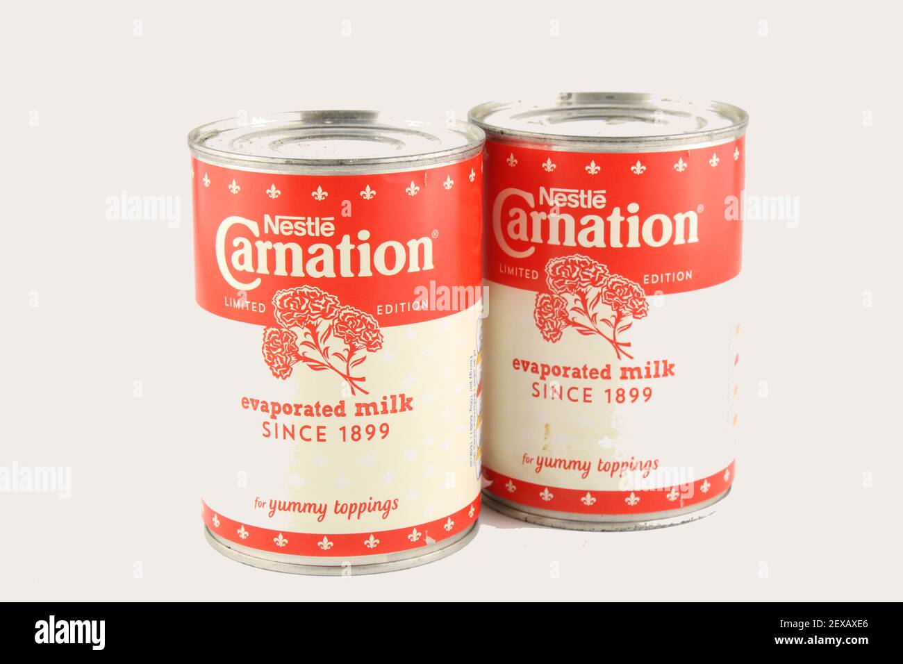 Two tins of Nestle Carnation evaporated milk with limited edition labels, isolated with copy space Stock Photo
