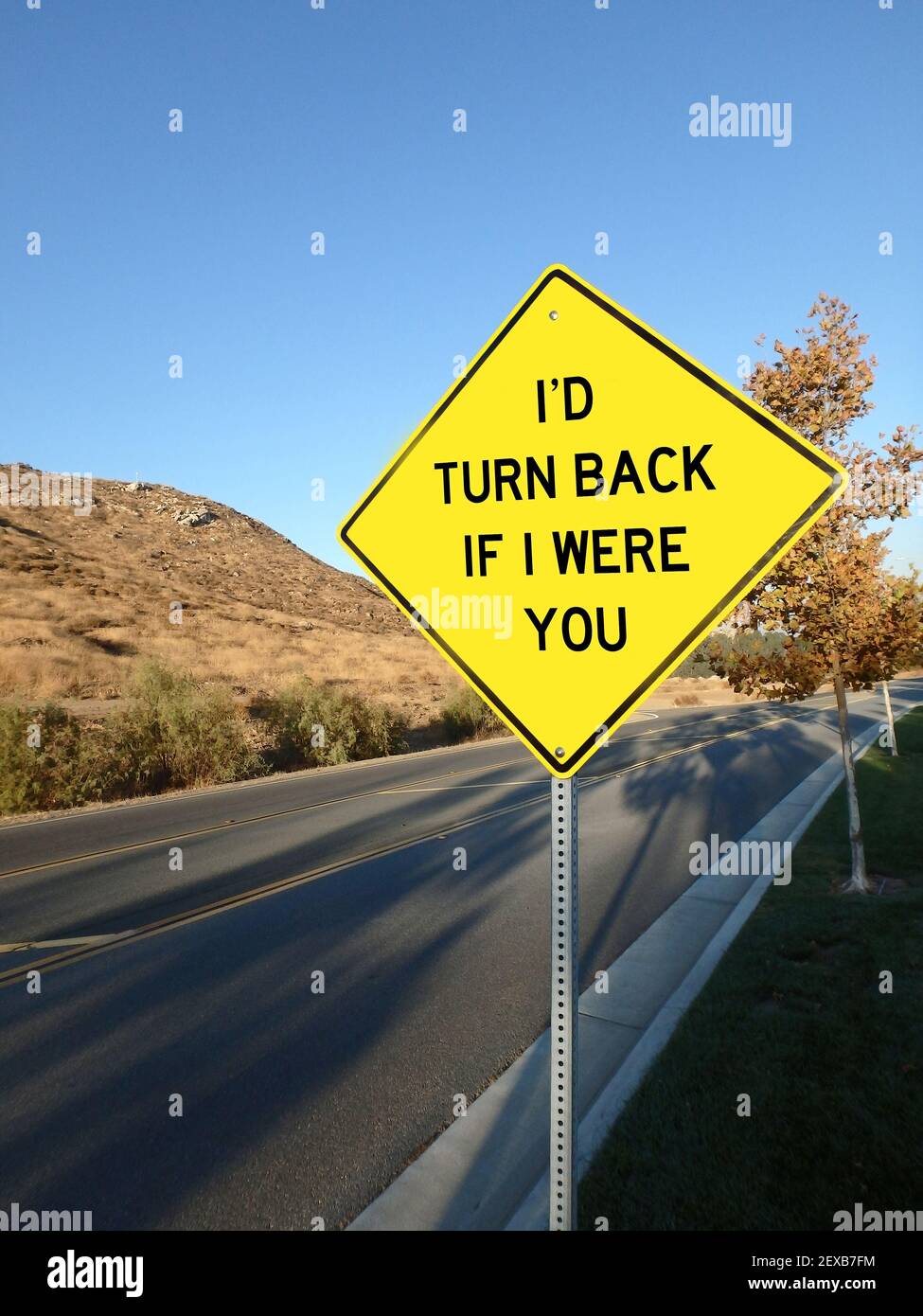 Yellow diamond road sign warning to turn back Stock Photo