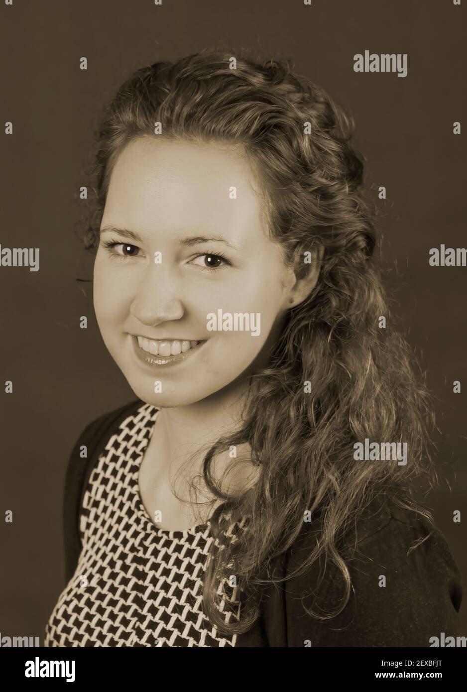 Portrait of young beautiful woman, she is wearing a dress and has curly