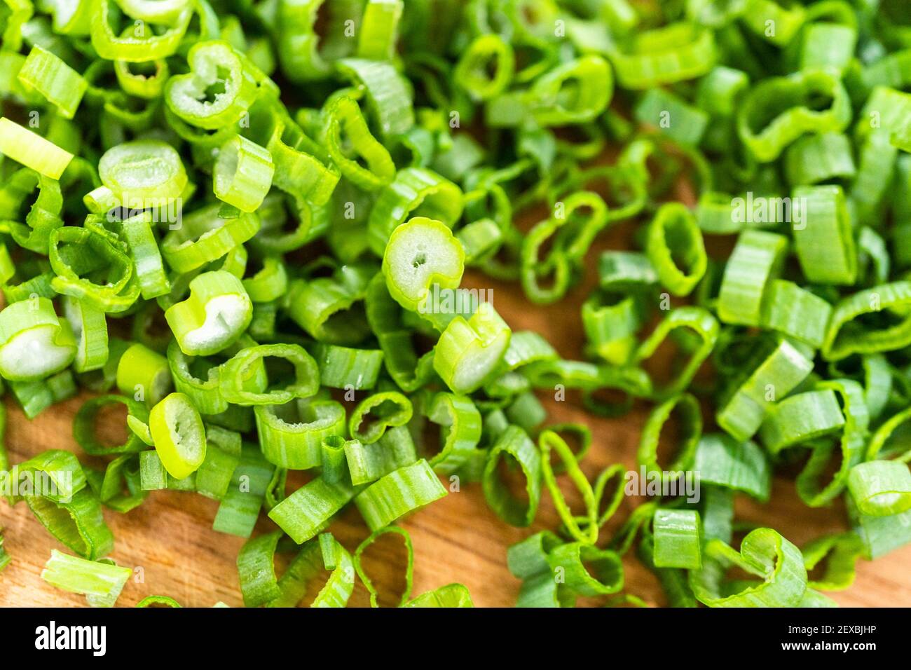 Chopping organic green onions on a wood cutting board Stock Photo - Alamy