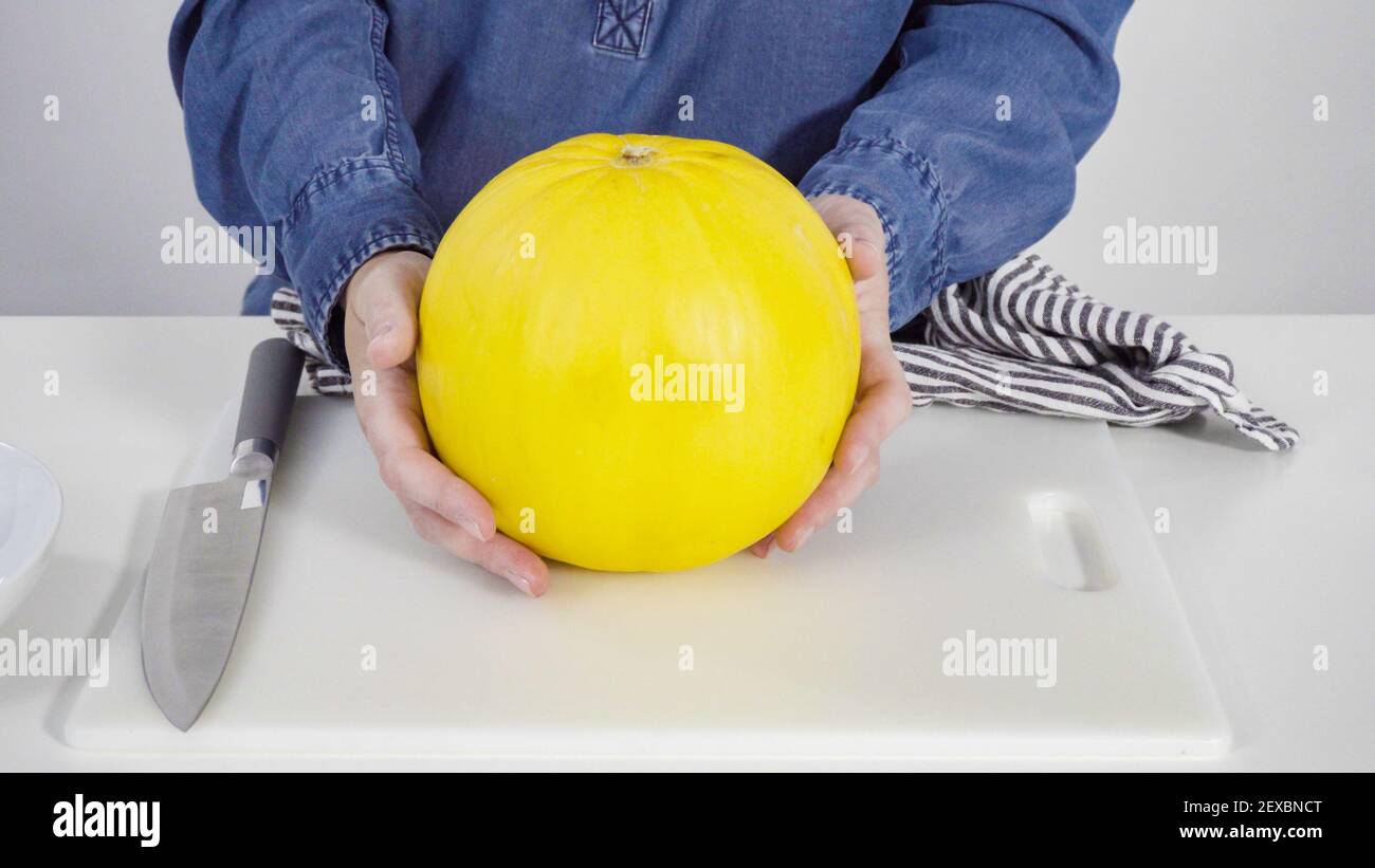 Step by step. Whole golden dewlicious melon on a white background Stock