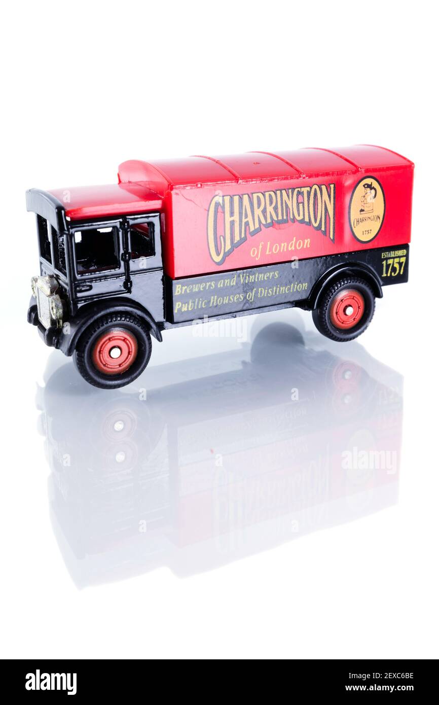 Worn diecast model of a vintage 'Charrington' brewer's lorry. Isolated on a white background, with reflection. Stock Photo