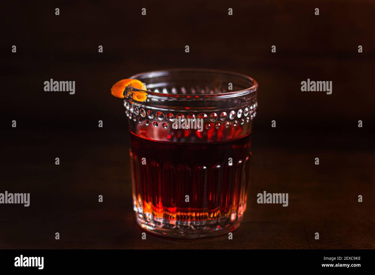 A Sazerac, a classic spirit-forward cocktail, sitting on a rustic wooden surface. Stock Photo