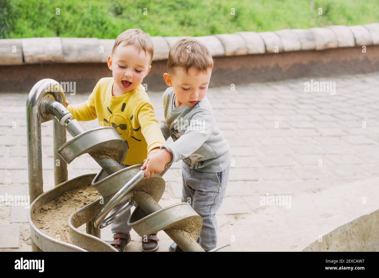 Twin brothers explore the metal construction of the Archimedes screw Stock Photo