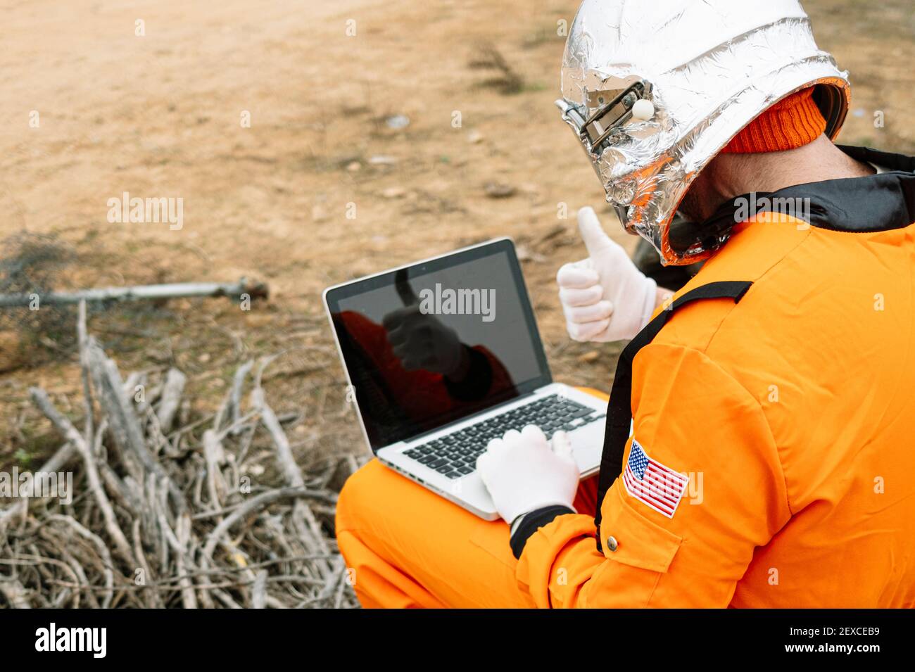 Man dressed as astronaut using laptop Stock Photo