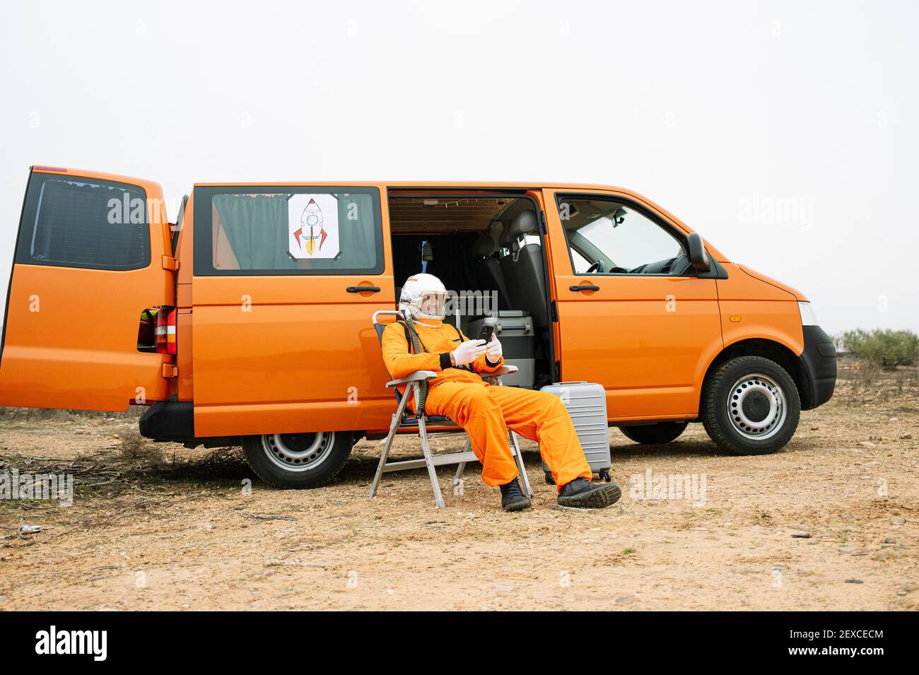 Man dressed as astronaut using smart phone Stock Photo