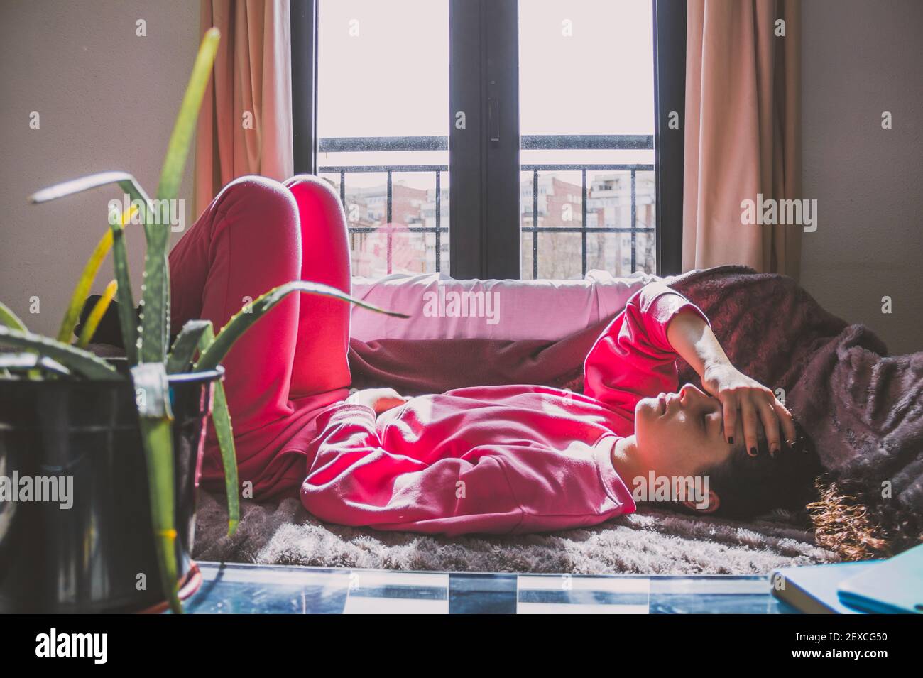 young woman lying on the sofa with a headache Stock Photo